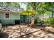 Backyard patio area with seating and green umbrella at 804 E 12Th Ave, New Smyrna Beach, FL 32169