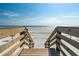 Wooden stairs provide direct access to a pristine beach with clear blue skies at 804 E 12Th Ave, New Smyrna Beach, FL 32169