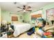 Cluttered bedroom with a ceiling fan and light green walls at 804 E 12Th Ave, New Smyrna Beach, FL 32169