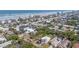 An aerial view shows neighborhood homes and mature trees near a coastline with multiple condo buildings at 833 E 12Th Ave, New Smyrna Beach, FL 32169