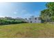 Expansive backyard with lush lawn, mature trees, and views of the home's exterior, perfect for outdoor activities at 833 E 12Th Ave, New Smyrna Beach, FL 32169