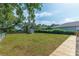 Lush backyard with a shed, a wooden path, mature trees, and ample greenery, ideal for relaxing at 833 E 12Th Ave, New Smyrna Beach, FL 32169
