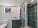 Bathroom featuring modern vanity, tiled shower, and a window at 833 E 12Th Ave, New Smyrna Beach, FL 32169