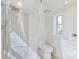Bright bathroom featuring a tiled shower with a glass door, a toilet, and a vanity sink with a window at 833 E 12Th Ave, New Smyrna Beach, FL 32169