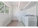 Functional laundry room with a window, natural light, and a washer and dryer set, providing convenience at 833 E 12Th Ave, New Smyrna Beach, FL 32169