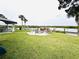 Well-manicured backyard features a firepit, dock, and waterfront views at 84 Heather Point Ct, New Smyrna Beach, FL 32169