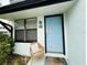 Close up of the front door with storm door and welcoming details like a welcome mat and chair at 84 Heather Point Ct, New Smyrna Beach, FL 32169