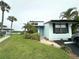Charming coastal home with lush landscaping, palm trees, and a peek of the water nearby at 84 Heather Point Ct, New Smyrna Beach, FL 32169