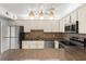 Stylish kitchen with granite countertops, stainless steel appliances, and bright lighting at 94 Cedar Dunes Dr, New Smyrna Beach, FL 32169
