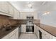 Well-lit kitchen with stainless steel appliances, light countertops, and ample cabinet space at 94 Cedar Dunes Dr, New Smyrna Beach, FL 32169