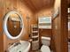 Cozy bathroom featuring white fixtures and natural wood walls at 125 Rio Vista Dr, Edgewater, FL 32132