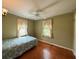 A cozy bedroom with a decorative bedspread, hardwood floors, and ample natural light at 125 Rio Vista Dr, Edgewater, FL 32132