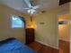Bright bedroom with a ceiling fan, a metal roof view from the window, and hardwood floors at 125 Rio Vista Dr, Edgewater, FL 32132