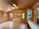 Cozy bedroom featuring natural wood walls, ceiling fan, and ample natural light at 125 Rio Vista Dr, Edgewater, FL 32132