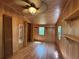 Bright bedroom featuring natural wood walls, ceiling fan, and built-in storage shelves at 125 Rio Vista Dr, Edgewater, FL 32132