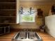 A close up on a stainless steel double kitchen sink with a view of a window and open shelving at 125 Rio Vista Dr, Edgewater, FL 32132