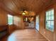 Open-concept living space with wood paneling, fireplace, and adjacent kitchen area at 125 Rio Vista Dr, Edgewater, FL 32132