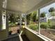 A cozy screened porch provides a tranquil view of the lush surroundings and a glimpse of the driveway at 125 Rio Vista Dr, Edgewater, FL 32132