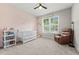 Charming Bedroom with a white crib, soft pink accent wall, and cozy reading chair at 1290 9Th St, Orange City, FL 32763