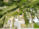 Aerial view of the property shows the home, detached buildings, and beautiful surrounding green space at 130 N Gaines St, Oak Hill, FL 32759