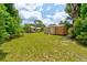 Backyard area shows grassy yard, outbuildings and home in the distance at 130 N Gaines St, Oak Hill, FL 32759
