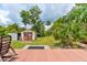 Charming backyard view showcasing a storage shed, green space, and lush landscaping from a wooden deck at 130 N Gaines St, Oak Hill, FL 32759