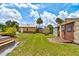 Backyard area of home shows grass, landscaping, and various outbuildings at 130 N Gaines St, Oak Hill, FL 32759