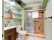 Bathroom features a glass enclosed shower, vanity with sink and cabinet, toilet and decorative shelving at 130 N Gaines St, Oak Hill, FL 32759