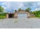 Metal building with roll up door and covered side area with storage racks at 130 N Gaines St, Oak Hill, FL 32759