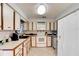 Functional kitchen featuring ample cabinetry, white appliances, and tile floors at 130 N Gaines St, Oak Hill, FL 32759