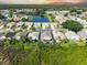 Aerial view of a home with mature landscaping and surrounding community, featuring a lake at 1327 Wayne Ave, New Smyrna Beach, FL 32168