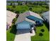Aerial view of a well-maintained home with a two-car garage, lush green lawn, and mature landscaping in a residential neighborhood at 1327 Wayne Ave, New Smyrna Beach, FL 32168