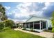 Charming backyard featuring a screened lanai, pergola, and brick-paved patio, perfect for outdoor living at 1327 Wayne Ave, New Smyrna Beach, FL 32168