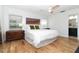 Bright bedroom featuring a white bedspread, wood floors, a ceiling fan, and ensuite bathroom at 1327 Wayne Ave, New Smyrna Beach, FL 32168