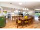 Open-concept kitchen and dining area with white cabinets, stainless steel appliances, and hardwood floors at 1327 Wayne Ave, New Smyrna Beach, FL 32168