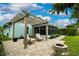 Beautiful backyard patio area with pergola, chairs, and a stone fire pit, ideal for relaxing and entertaining at 1327 Wayne Ave, New Smyrna Beach, FL 32168