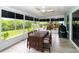 A cozy sunroom featuring a wooden dining set and serene views of the well-maintained backyard at 1327 Wayne Ave, New Smyrna Beach, FL 32168