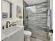Stylish bathroom featuring a farmhouse sink, wood-look tile accent, and a frameless glass shower at 1382 Coronet Dr, Deltona, FL 32725