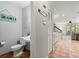 Hallway view with half bath featuring a pedestal sink and beach themed decorations at 140 Limewood Pl # C, Ormond Beach, FL 32174
