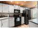 Efficient kitchen with white cabinets, black appliances and wood plank ceiling at 140 Limewood Pl # C, Ormond Beach, FL 32174