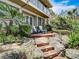 Charming backyard featuring lush landscaping, wooden steps, and cozy deck area at 1421 N Atlantic Ave, New Smyrna Beach, FL 32169