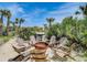 Cozy backyard with a relaxing fire pit surrounded by chairs and natural landscaping at 1421 N Atlantic Ave, New Smyrna Beach, FL 32169