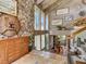 Grand foyer with natural stone accent wall, wood trim, unique decor, and stairs with glass panels at 1421 N Atlantic Ave, New Smyrna Beach, FL 32169