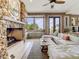 Inviting living room featuring a stone fireplace, large windows with beach views, and comfortable sectional seating at 1421 N Atlantic Ave, New Smyrna Beach, FL 32169