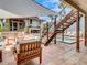 Relaxing brick patio featuring a canopy, glass enclosed stairs, and ample seating around a beautiful pool at 1421 N Atlantic Ave, New Smyrna Beach, FL 32169