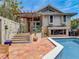 Outdoor pool area showcasing the tiled patio, outdoor pergola and lush tropical surroundings at 1421 N Atlantic Ave, New Smyrna Beach, FL 32169