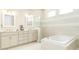 Bright bathroom featuring double vanity, soaking tub, and tile accents at 150 Portofino Blvd, New Smyrna Beach, FL 32168
