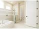 Light and bright bathroom featuring soaking tub, walk-in shower, and tiled flooring at 150 Portofino Blvd, New Smyrna Beach, FL 32168