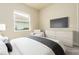 Comfortable bedroom featuring a mounted TV, stylish dresser, and large window at 150 Portofino Blvd, New Smyrna Beach, FL 32168