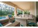Inviting covered patio with comfortable seating and a serene view of the pool and lush backyard at 150 Portofino Blvd, New Smyrna Beach, FL 32168
